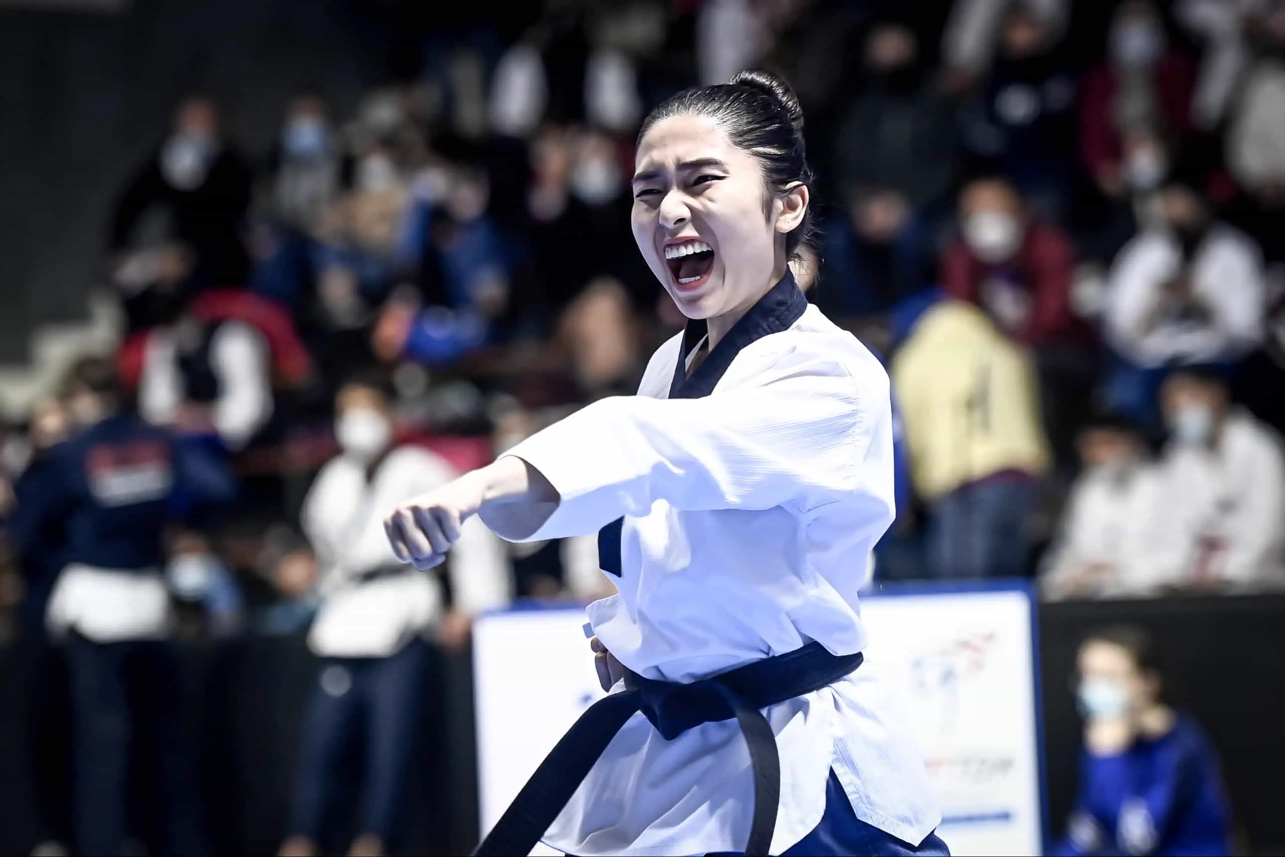 Une compétitrice de poomsae exécute une technique, accompagnée du kihap.